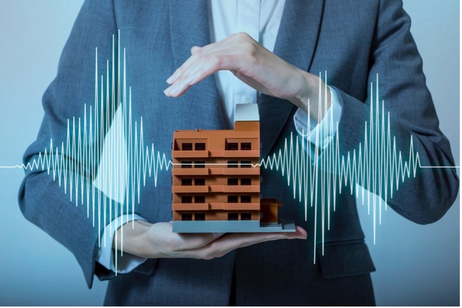 A person holding a model of a building